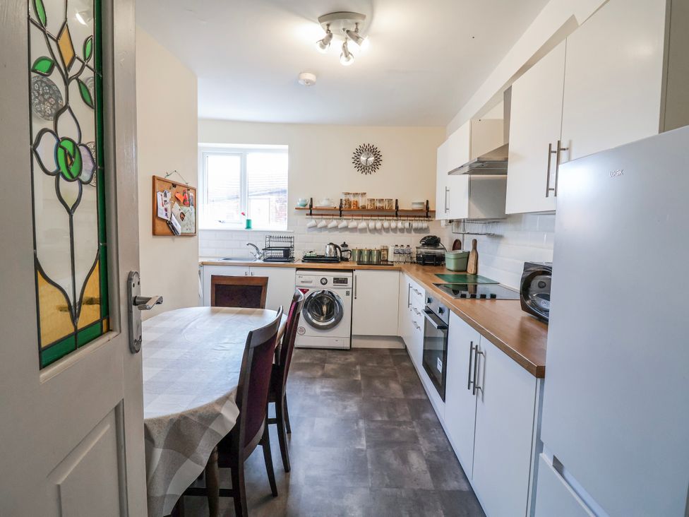 A kitchen with a table and appliances at Top floor apartment
