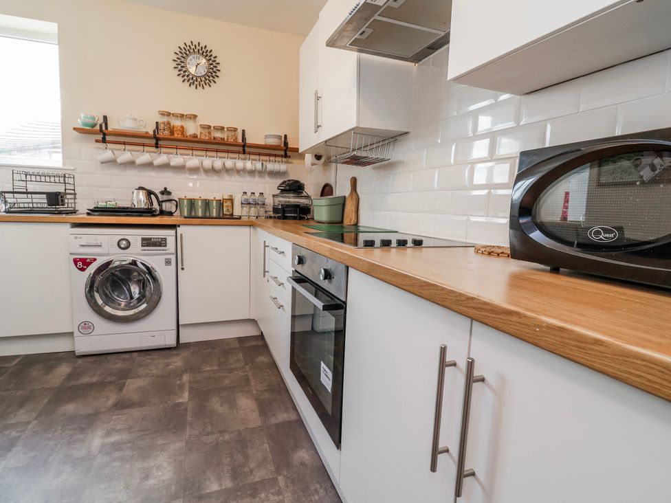 A kitchen with washing machine and microwave at Top floor apartment 