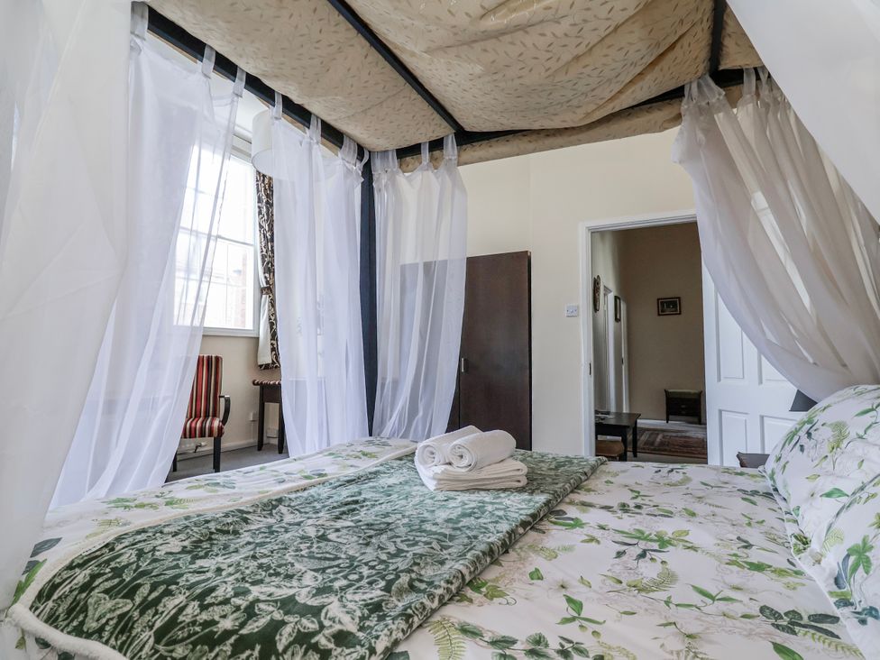A bedroom with a canopy bed and view of a chair at Top floor apartment 