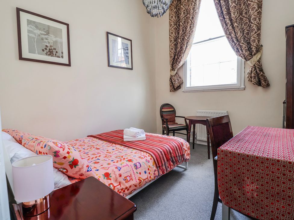 A bedroom with a bed, table, and chair at Top floor apartment