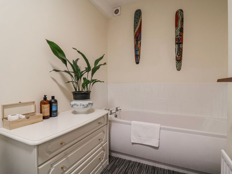 A bathroom with a bathtub and plant at Top floor apartment 