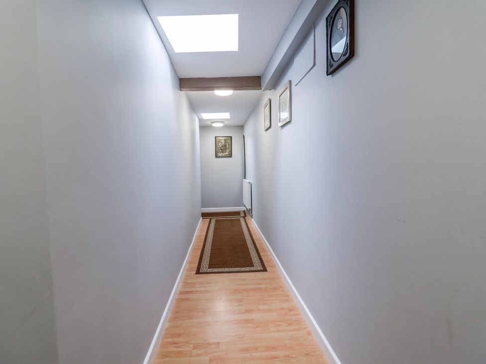 A hallway with a rug and framed artwork at Top floor apartment 