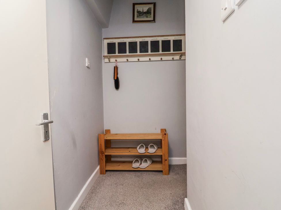 A hallway with a shoe rack and hooks at Top floor apartment