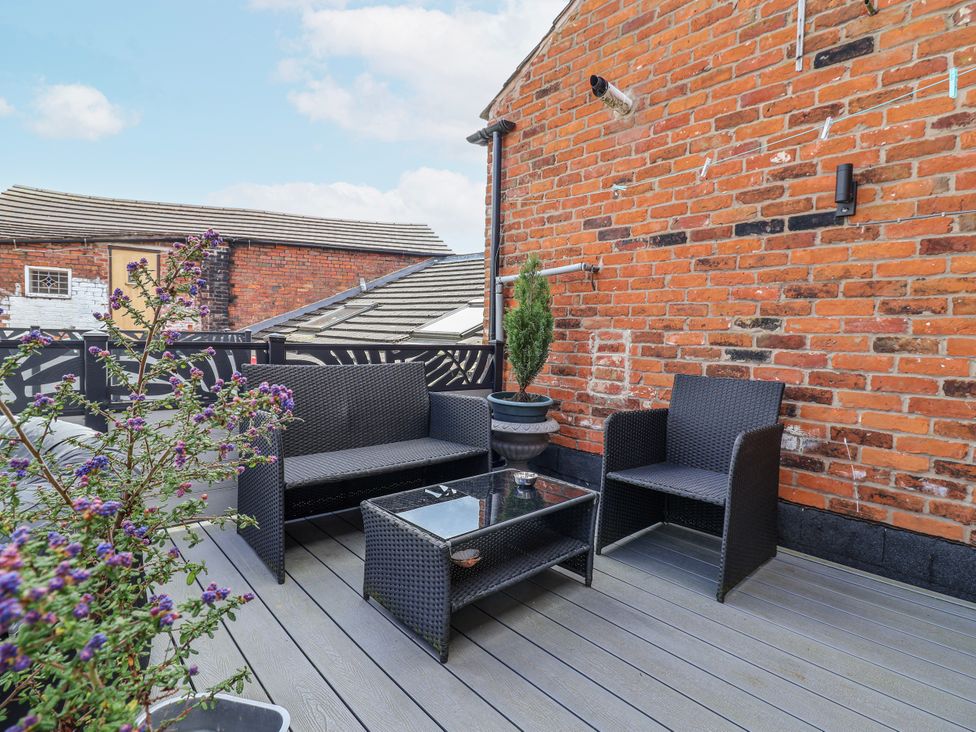 An outdoor terrace with seating and a potted plant at Top floor apartment