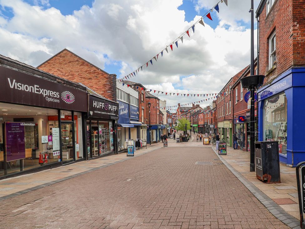 A pedestrian street with shops and bunting at a shopping area