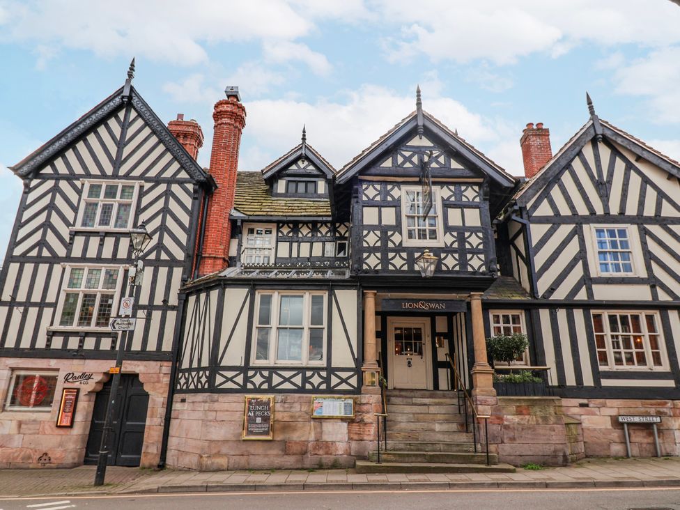 A building with black and white timber framing and stairs at Lion & Swan