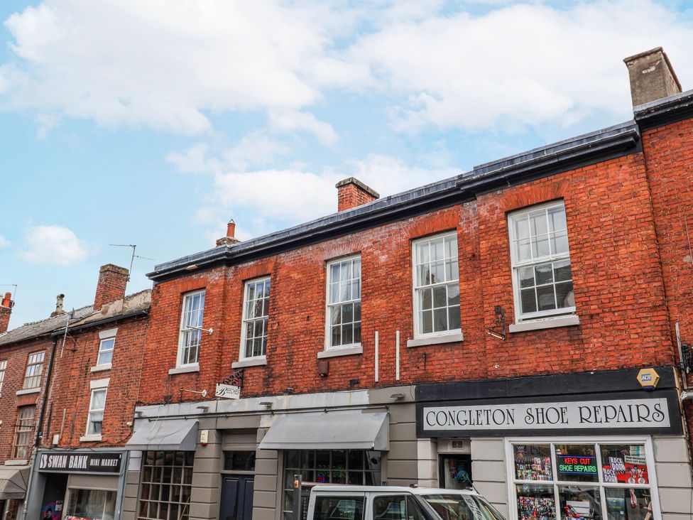 A brick building with windows and a shopfront at Top floor apartment in 