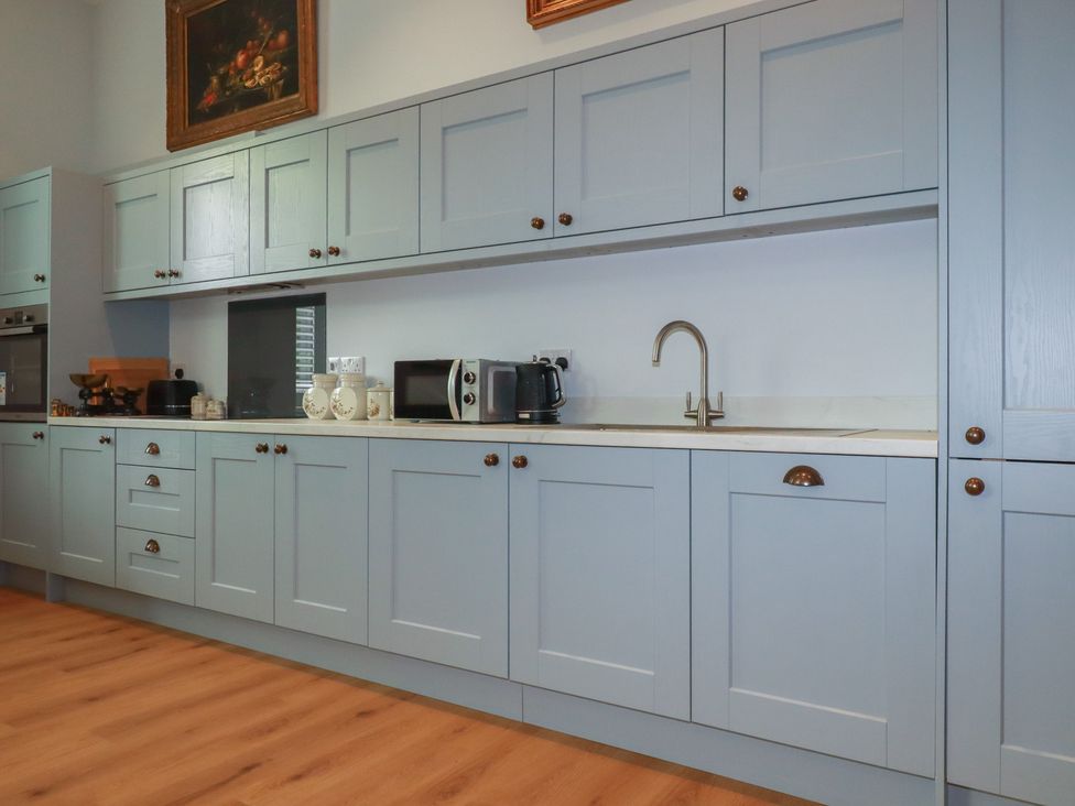 A kitchen with cabinets and appliances at Farthings, The Old Chapel St. Austell