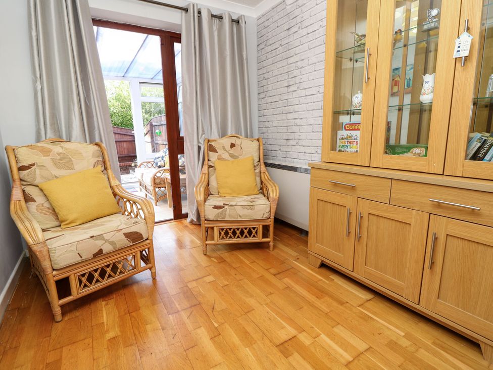 A snug with armchairs and a shelf unit at 73 Pennywell Gardens in New Milton