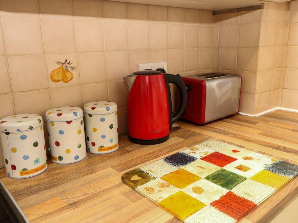 A kitchen countertop with a kettle, toaster, canisters, and a placemat at 73 Pennywell Gardens in New Milton