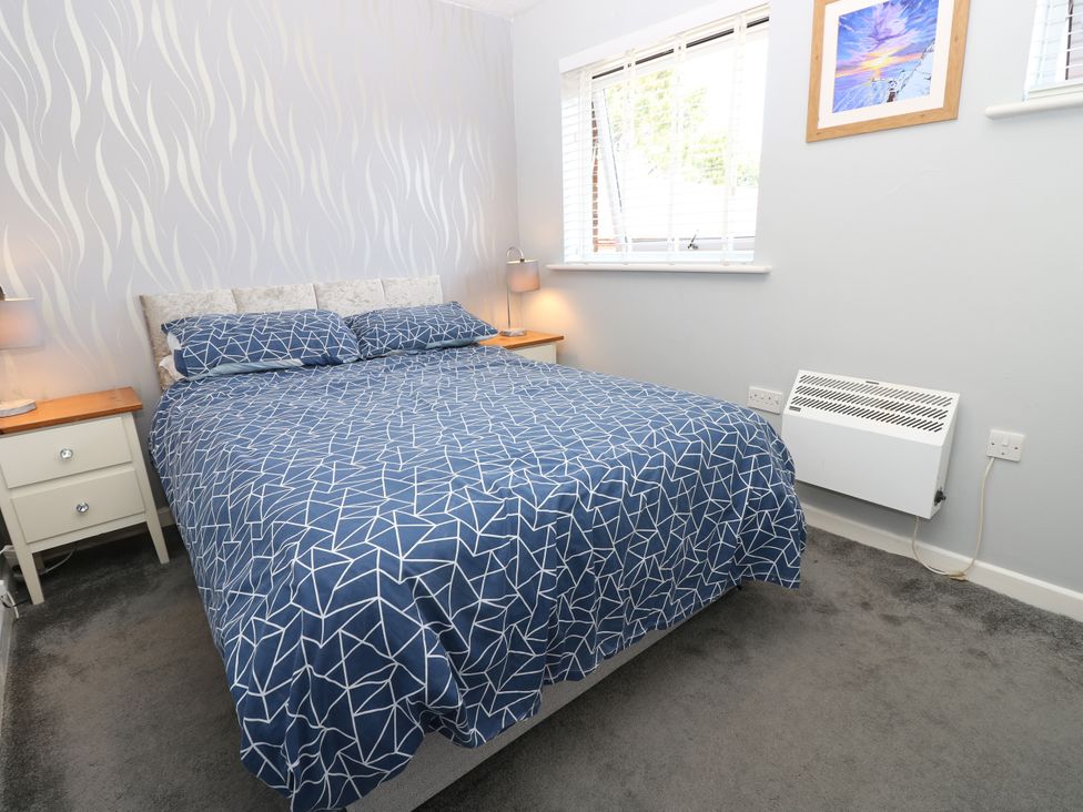A bedroom with a bed and bedside table at 73 Pennywell Gardens in New Milton