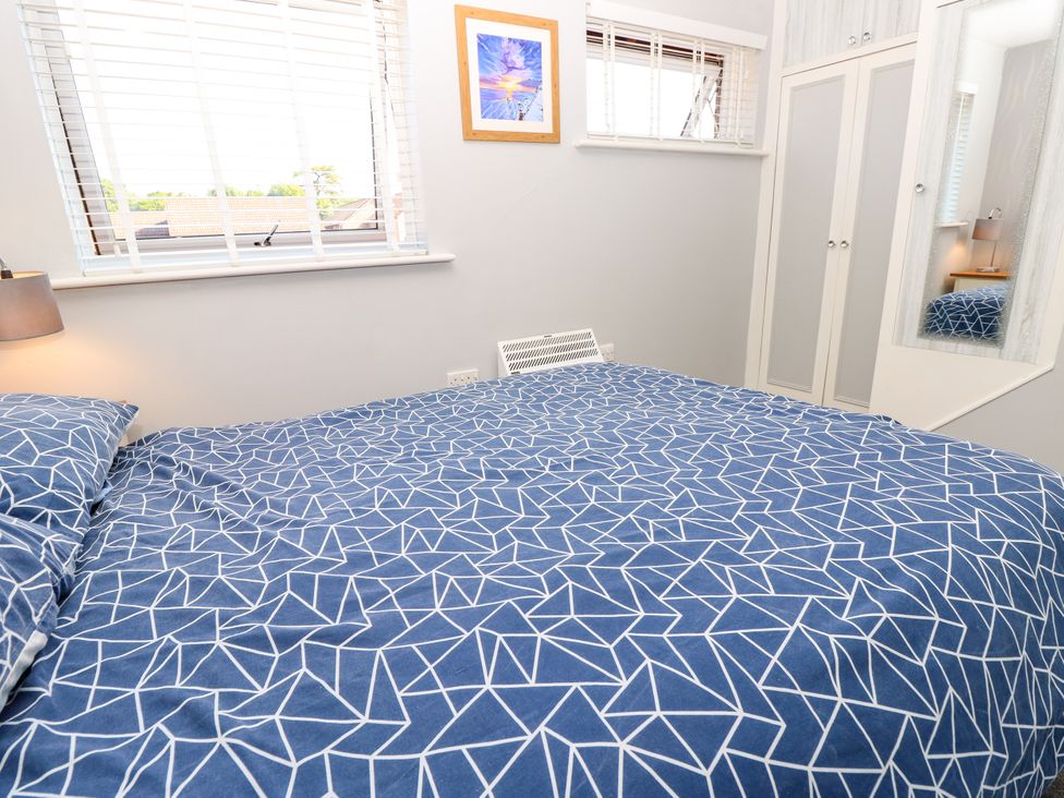 A bedroom featuring a bed, lamp, and wardrobe at 73 Pennywell Gardens in New Milton