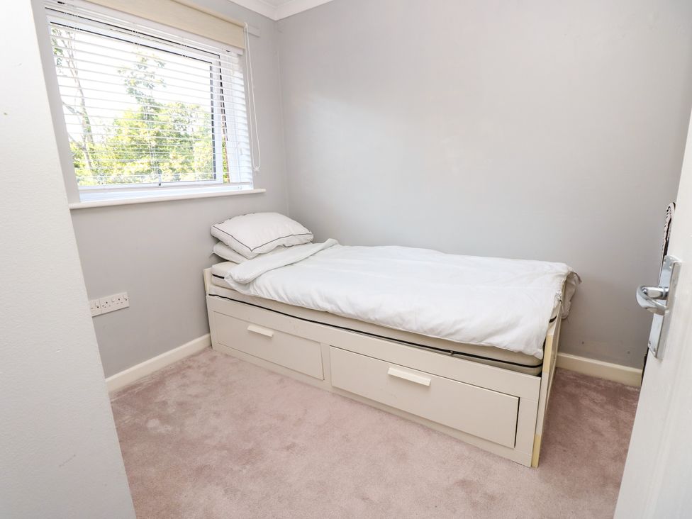 A bedroom with a bed and window at 73 Pennywell Gardens in New Milton