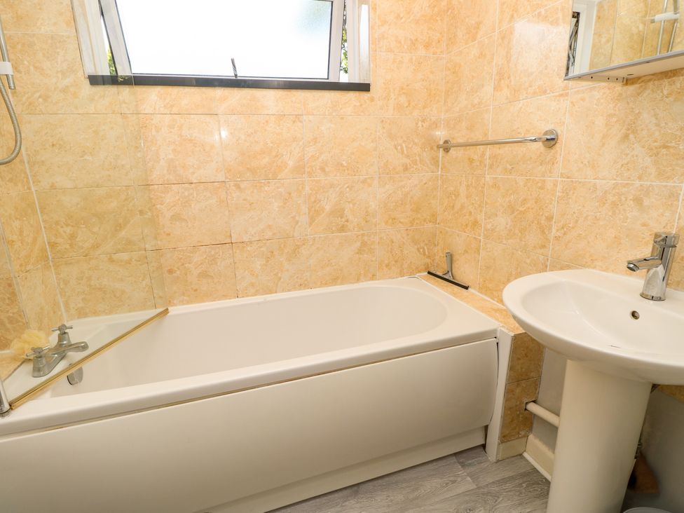 A bathroom with a bathtub and sink at 73 Pennywell Gardens in New Milton