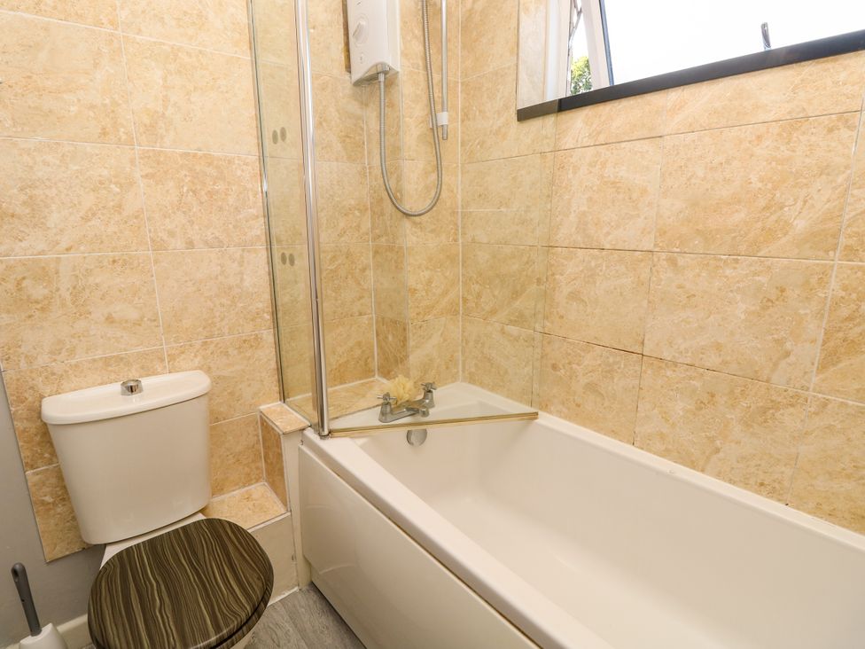 A bathroom with a bathtub and shower at 73 Pennywell Gardens New Milton