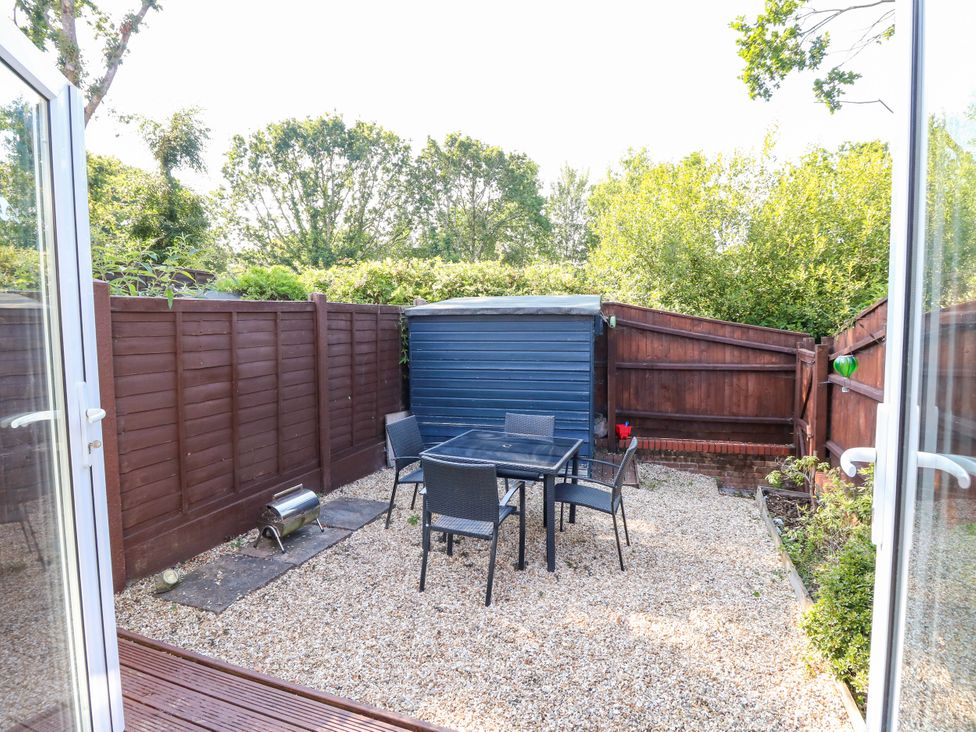 A garden with a table and chairs at 73 Pennywell Gardens in New Milton