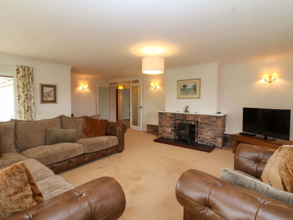 A living room with a fireplace and television at 26 Five Bells in Watchet