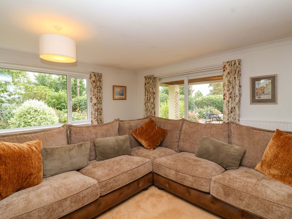A living room with a sofa and windows at 26 Five Bells in Watchet