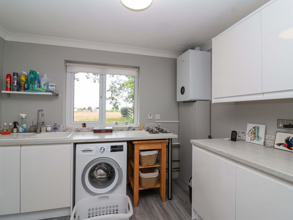 A kitchen with a washing machine and sink at 26 Five Bells in Watchet