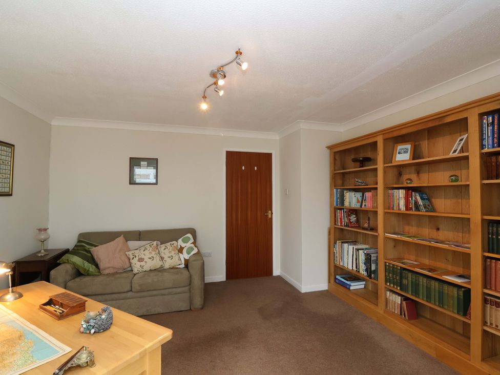 A living room with a sofa and bookshelf at 26 Five Bells in Watchet