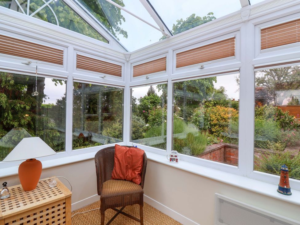 A conservatory with a chair and table in 26 Five Bells Watchet