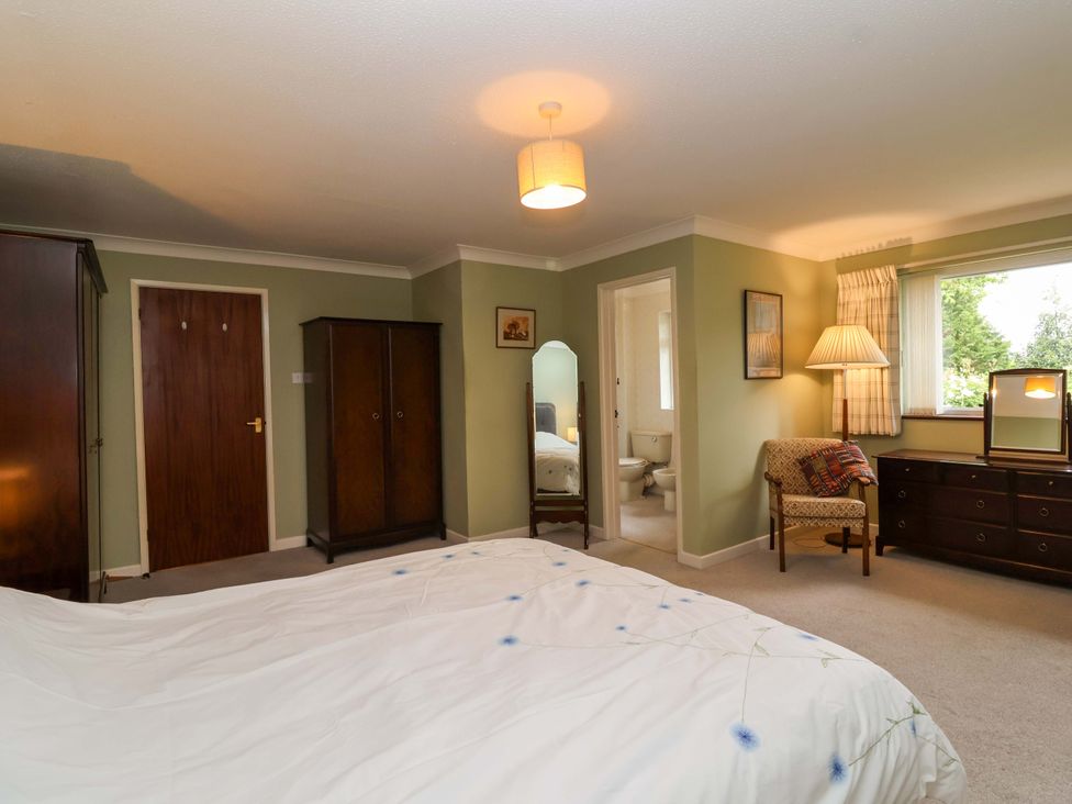 A bedroom with a bed, wardrobe, and window at 26 Five Bells Watchet