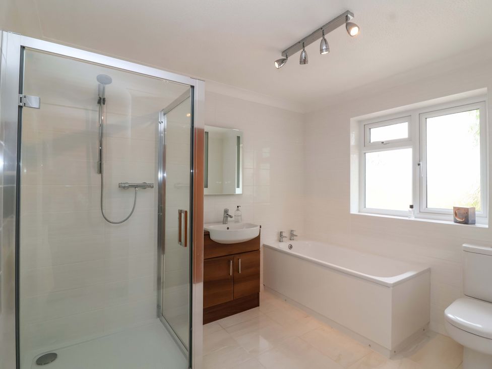 A bathroom featuring a shower, bathtub, and sink at 26 Five Bells in Watchet