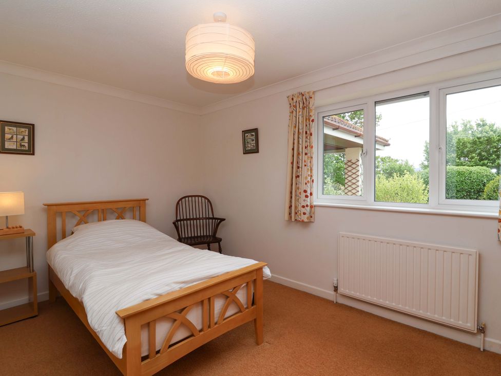 A bedroom with a bed and a chair at 26 Five Bells, Watchet