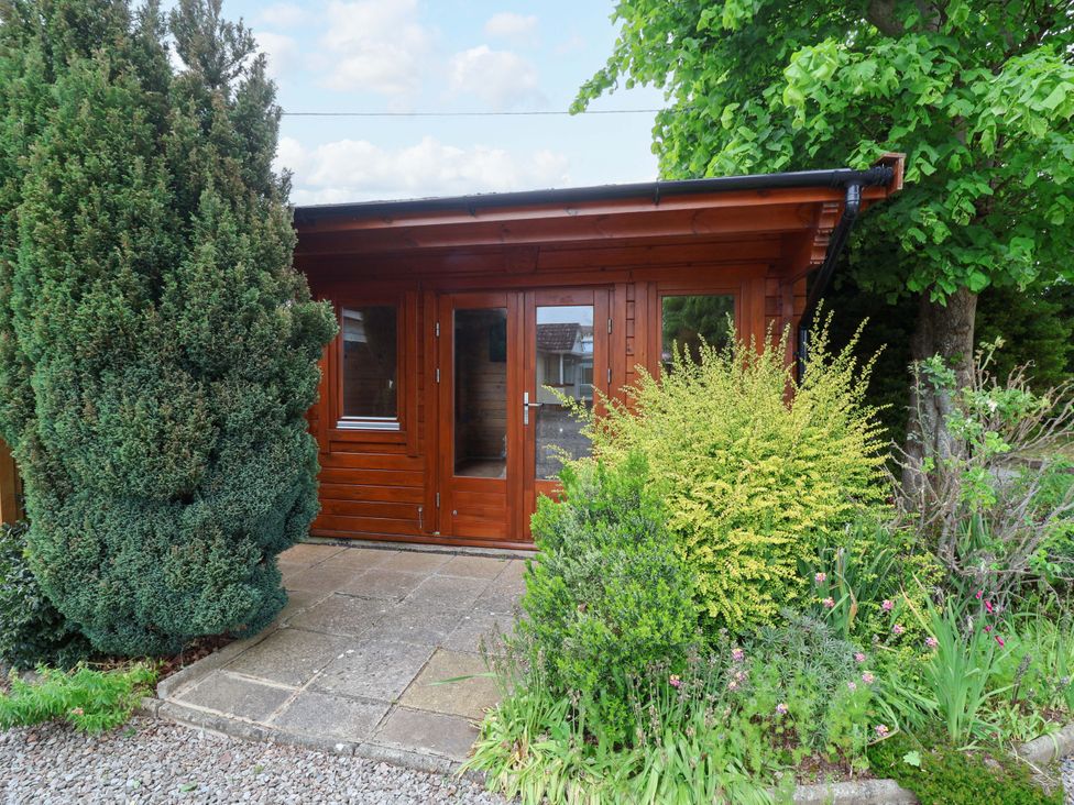 A wooden cabin with plants in the garden at 26 Five Bells Watchet