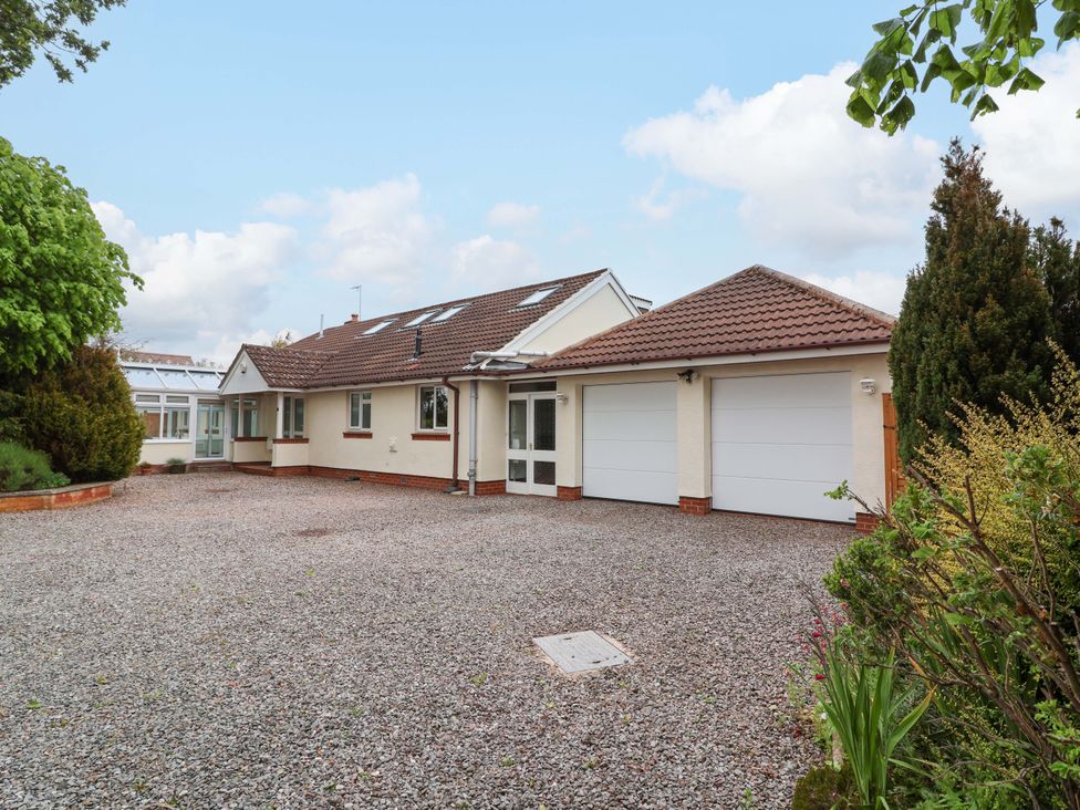 A house with a gravel driveway and two garage doors at 26 Five Bells in Watchet