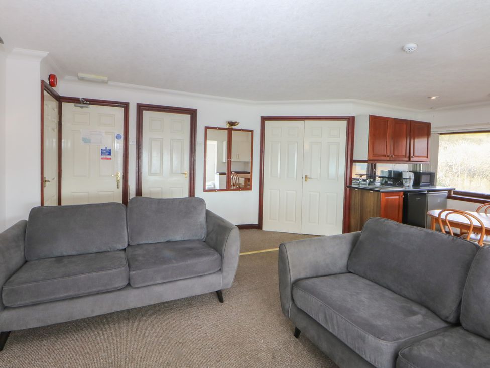 A living room with sofas and kitchen units at Seaview in Y Felinheli
