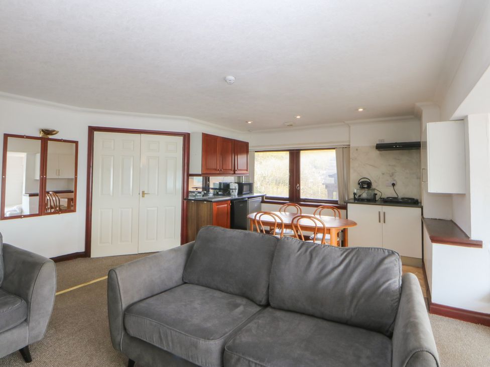 A living room with a sofa and dining area at Seaview in Y Felinheli