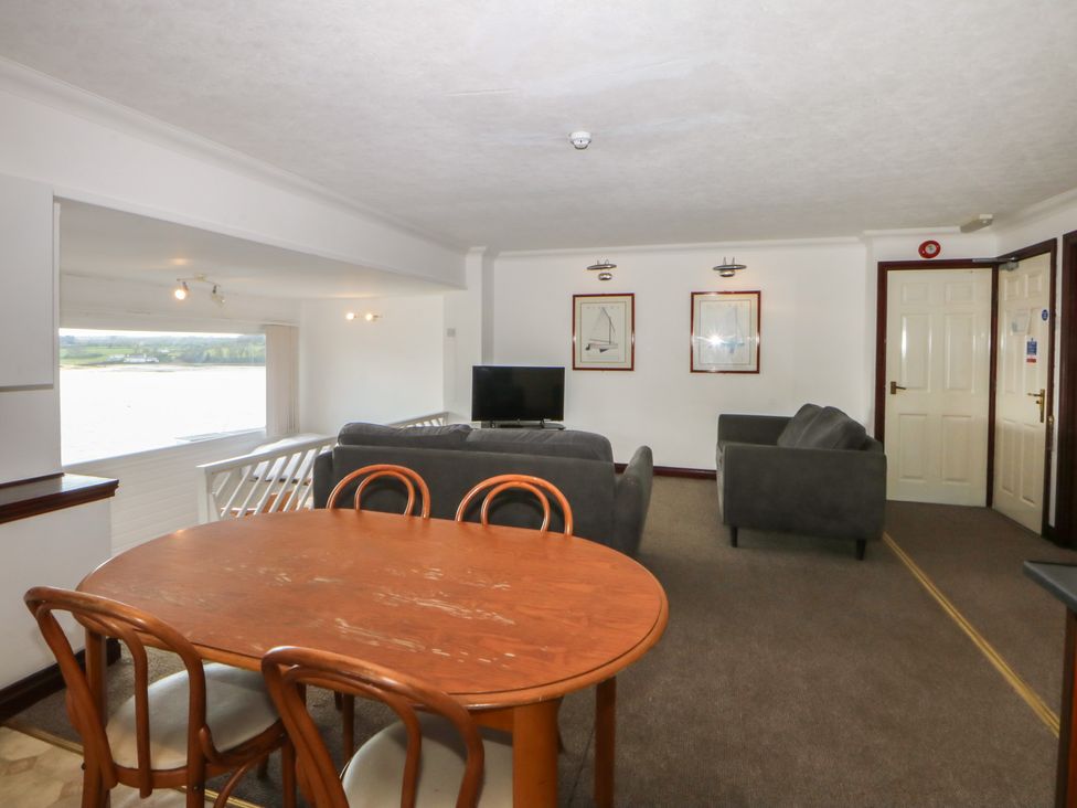 A living room with a table, chairs, sofa and television at Seaview in Y Felinheli
