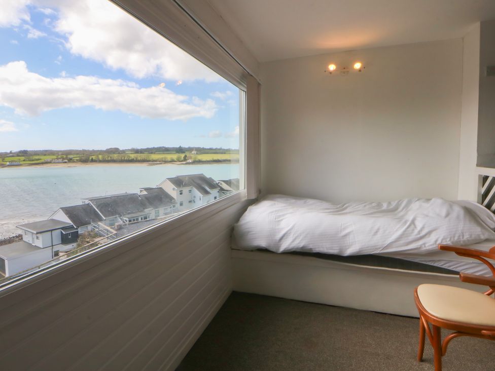 A bedroom with a bed and a view of the water at Seaview in Y Felinheli