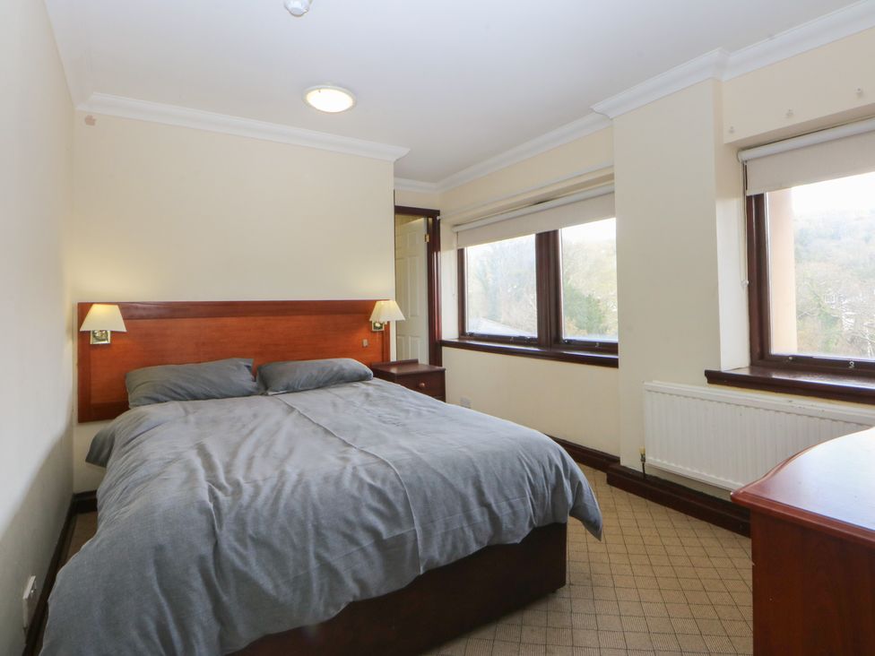 A bedroom with a bed and windows at Seaview in Y Felinheli
