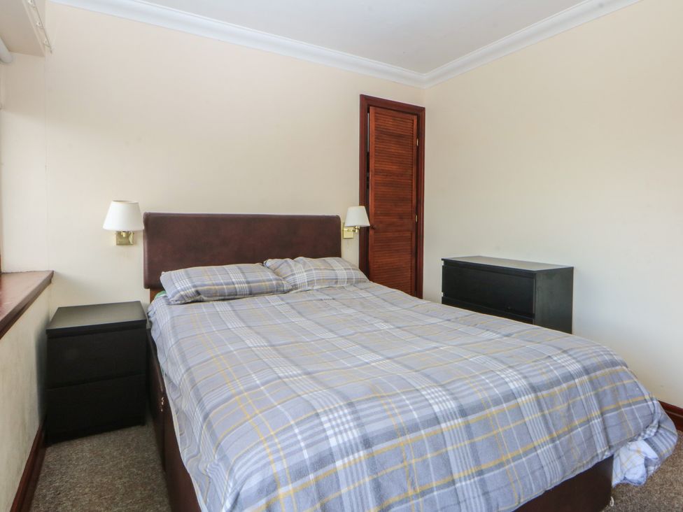 A bedroom with a bed and nightstand at Seaview in Y Felinheli