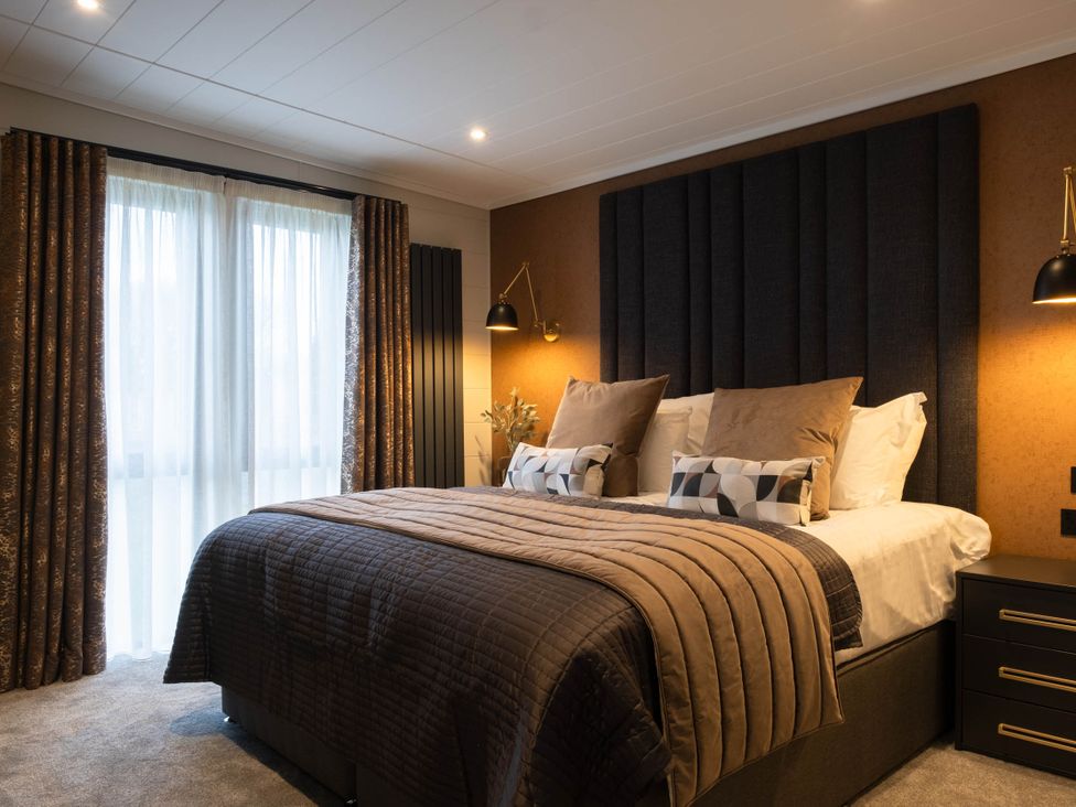 A bedroom with a bed and curtains at Exclusive Tempest Spa in Grimsby
