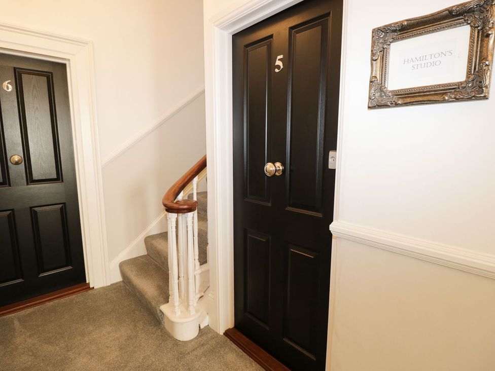 A hallway with doors and a staircase at Hamilton's Studio in Ryde