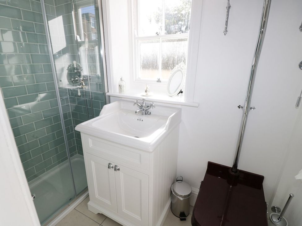 A bathroom with a shower, sink, and toilet at Hamilton's Studio in Ryde
