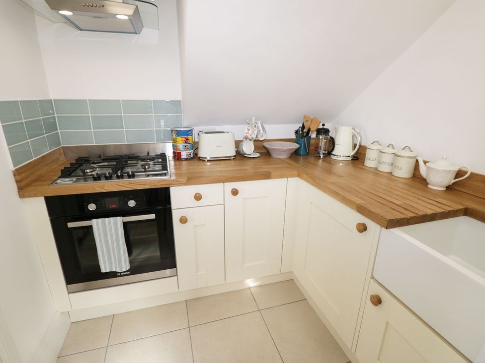 A kitchen with a gas stove, oven, and countertop appliances at Hamilton's Studio in Ryde