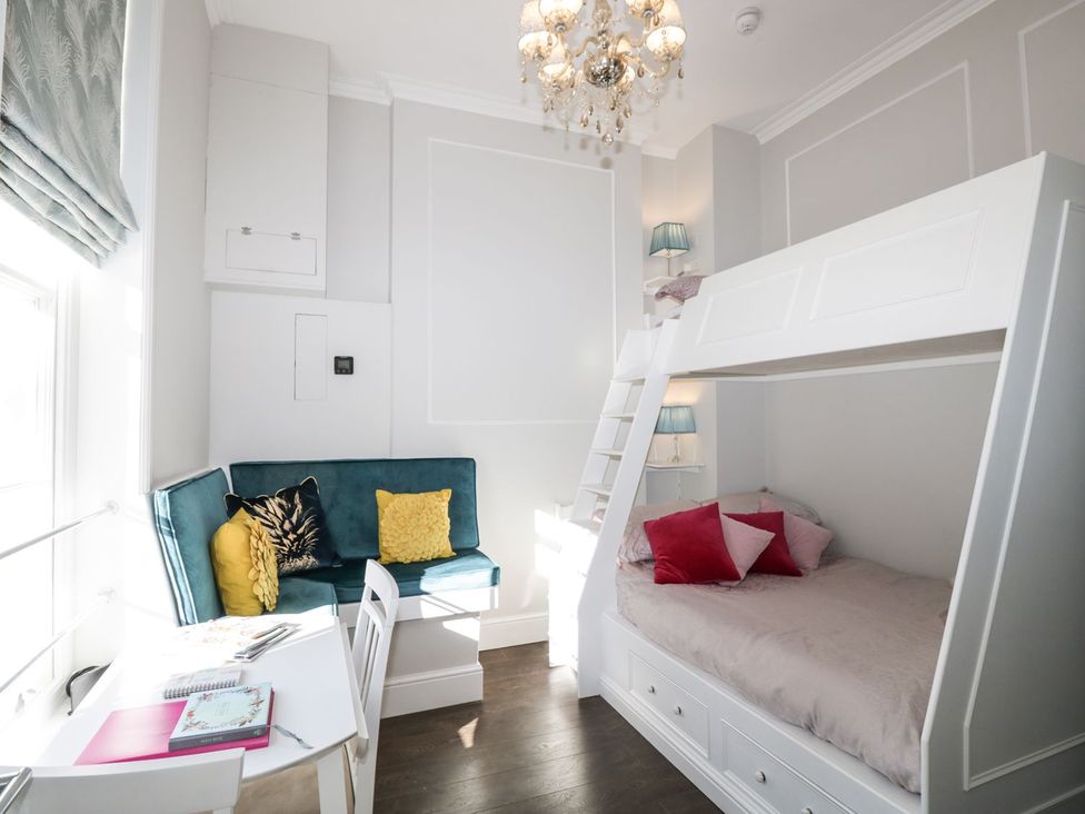 A bedroom with a bunk bed and a seating area at Hamilton's Studio in Ryde
