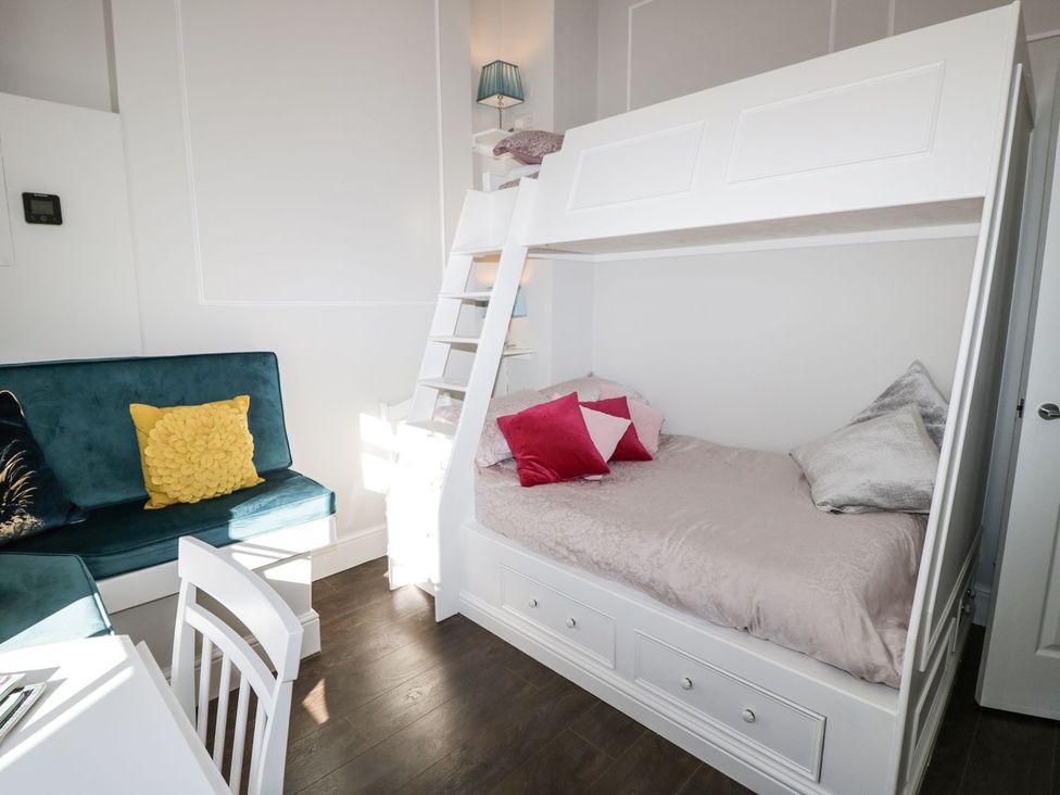 A bedroom with a bunk bed and seating area at Hamilton's Studio in Ryde