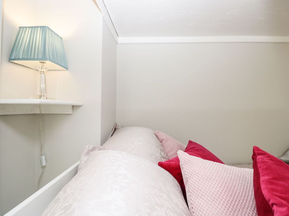 A bedroom with a lamp and pillows at Hamilton's Studio in Ryde