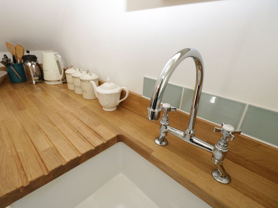A kitchen counter with a faucet and kitchen appliances at Hamilton's Studio in Ryde