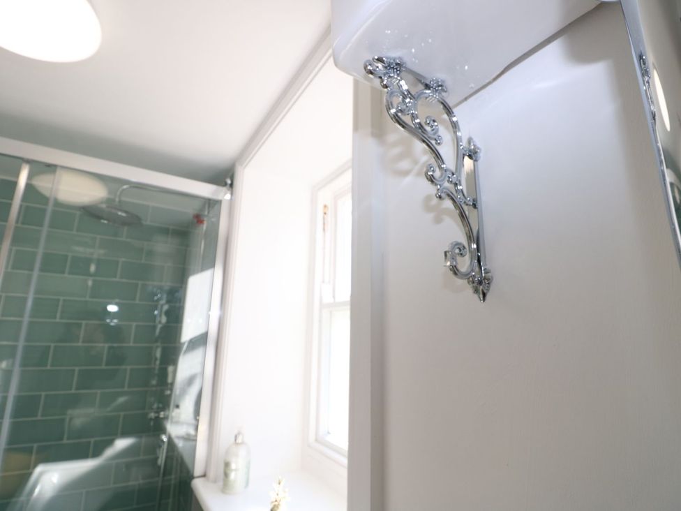 A bathroom with a shower and a wall shelf at Hamilton's Studio in Ryde