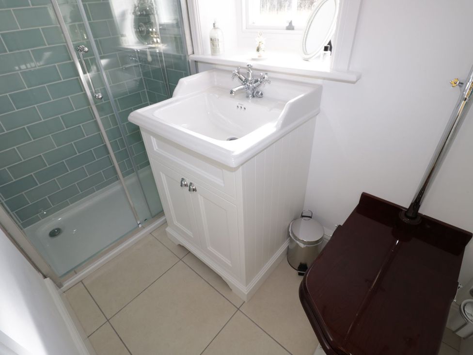 A bathroom with a sink, shower, and toilet at Hamilton's Studio in Ryde