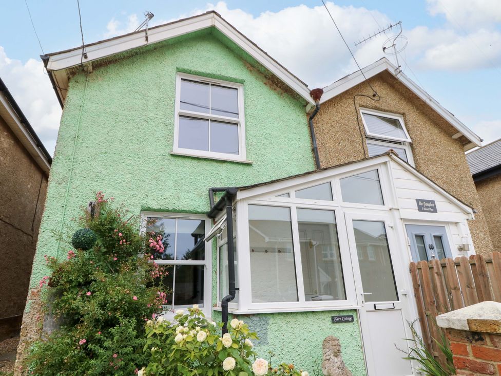 A green house with a porch and plants at Fern Cottage in Bembridge