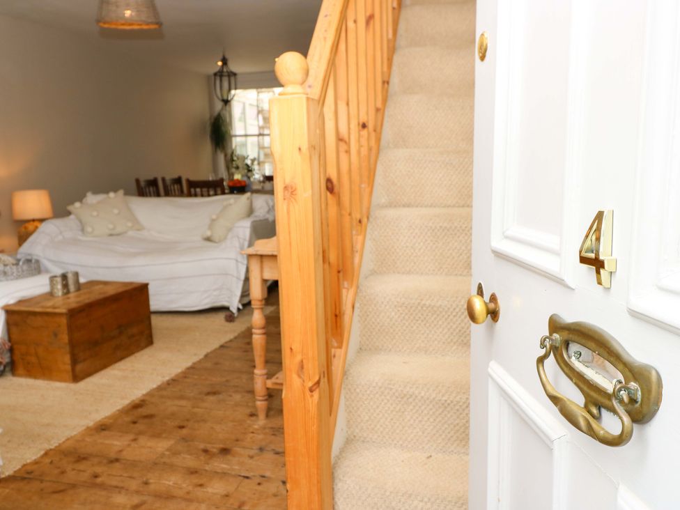 A living room with a staircase and furniture at Fern Cottage in Bembridge