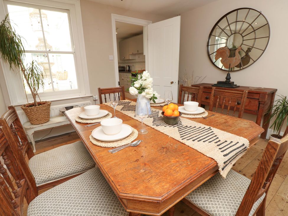 A dining room with a wooden table and chairs at Fern Cottage in Bembridge