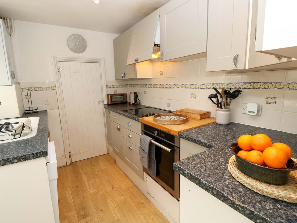 A kitchen with sink and oven at Fern Cottage in Bembridge